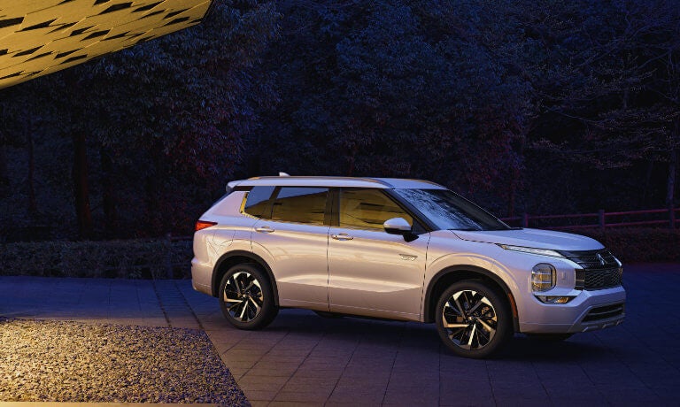 2024 Mitsubishi Outlander PHEV parked outside a home at night